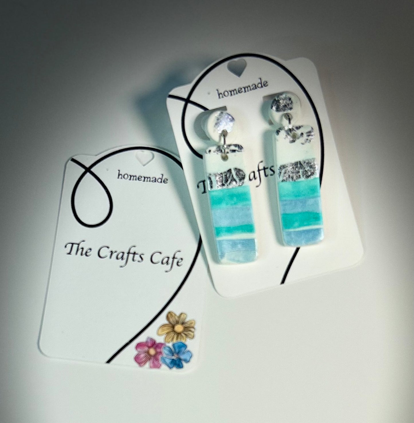 Seafoam stacked polymer clay earrings with silver foil on branded card