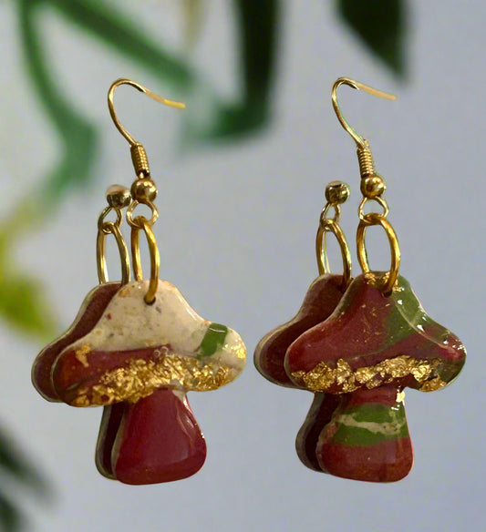 Mushroom-shaped earrings with gold accents on a beige background